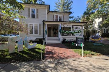 The outside of the Burtch House is decorated for Homecoming with green  and white balloons, a Homecoming sign and the letters HTC
