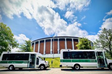 Two OHIO shuttles are parked in front of the Convocation Center