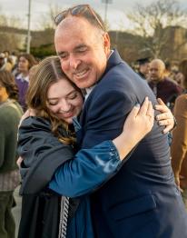 a Bobcat hugging their parent after their commencement ceremony