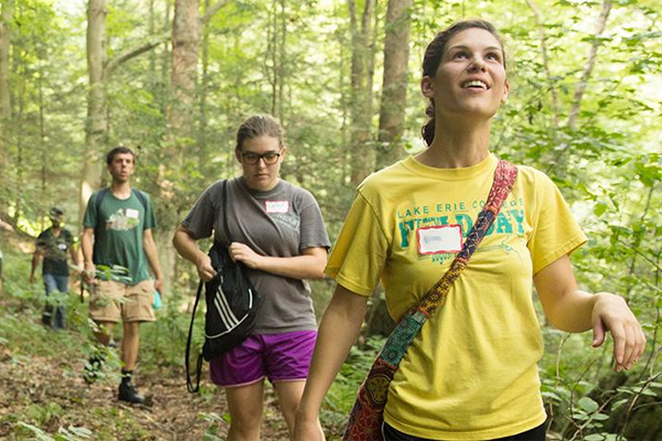 Students hiking through the woods. 