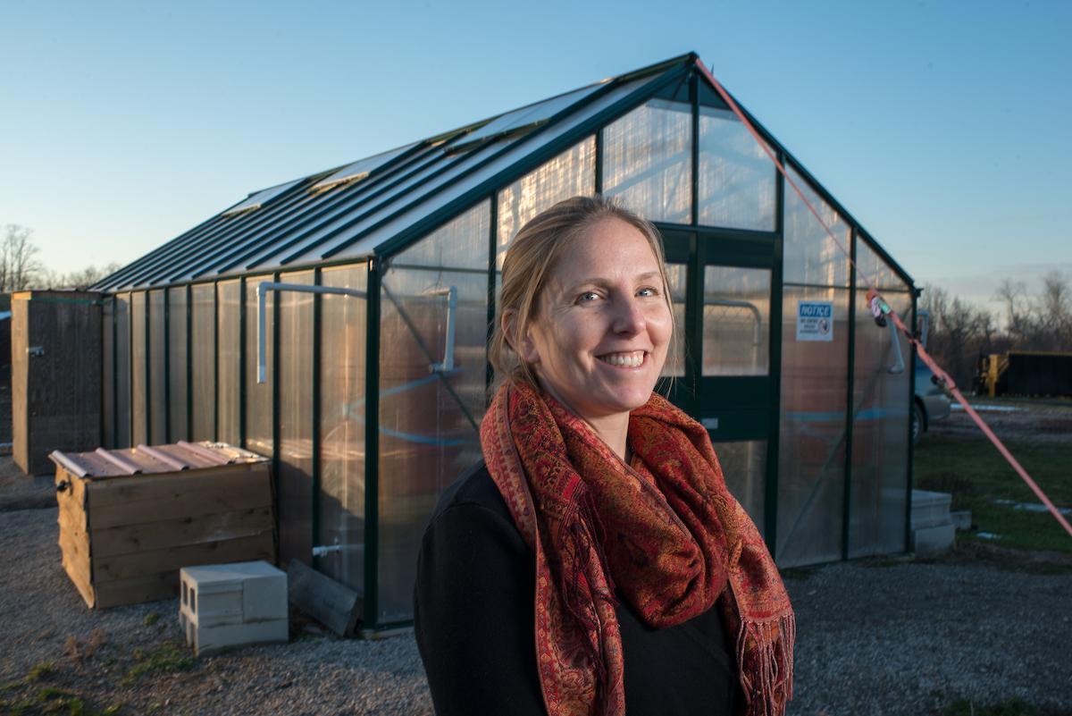 Sarah Davis standing in front of a greenhouse
