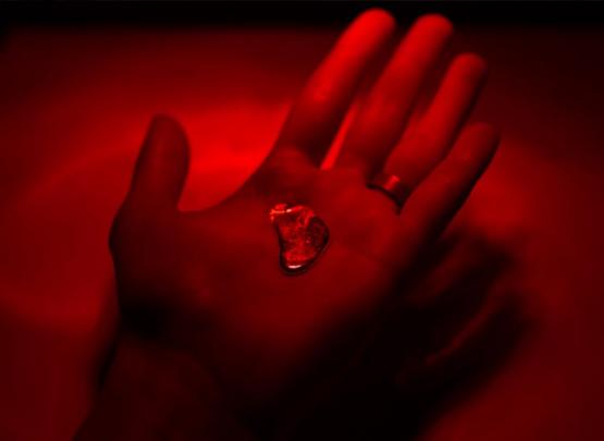 Close-up of a hand holding the chemical element gallium, as part of the "shape of the future" art exhibit.